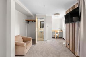 a living room with a couch and a television at Hotel Comenius in Berlin