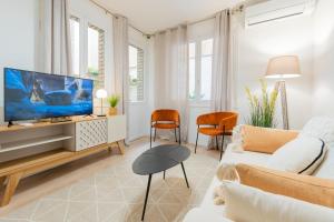ein Wohnzimmer mit Fernseher und Sofa in der Unterkunft Apartamento de 1 dormitorio cerca de Plaza España-Madrid Temporal PEZ14 in Madrid