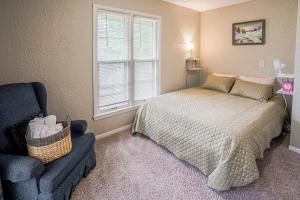 una camera da letto con un letto, una sedia e una finestra di Pet-Friendly St Paul Home Fireplace and Office Area a Mendota