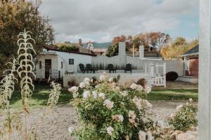 una casa bianca con dei fiori in giardino di Hol Gok Patagonia a Esquel