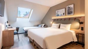 een hotelkamer met twee bedden en een bureau bij Campanile NATURE - Aix Les Bains in Aix-les-Bains