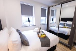 a bedroom with two beds and a mirror at Modern Borehamwood Flat - 2 Min Walk to Station in Borehamwood