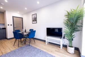a dining room with a table and a potted plant at Modern Borehamwood Flat - 2 Min Walk to Station in Borehamwood