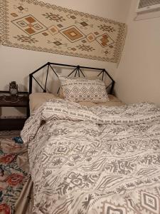 ein Bett mit einer Bettdecke und einem Kissen darauf in der Unterkunft الدارالجميلة دارهيفاء in Medina