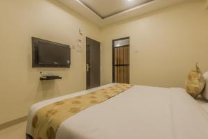 a bedroom with a bed and a flat screen tv at Super Hotel O Palace Inn Near Don Bosco (Borivali) Metro Station in Mumbai