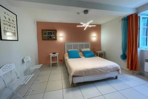 a bedroom with a bed with blue pillows on it at Lassegues in Castetner