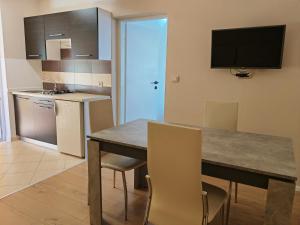 a kitchen with a table and chairs and a television at Apartments Sandra in Vrsar