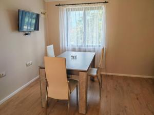a dining room with a table and chairs and a window at Apartments Sandra in Vrsar
