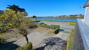 a tree in a parking lot next to a river at Studio Carnac Plage Terrasse & Parking privé in Carnac