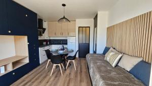 a living room with a couch and a table and a kitchen at Studio Carnac Plage Terrasse & Parking privé in Carnac