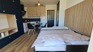 a bedroom with a large bed and a kitchen at Studio Carnac Plage Terrasse & Parking privé in Carnac +3 photos