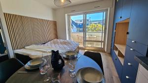 a room with a table with glasses and a bed at Studio Carnac Plage Terrasse & Parking privé in Carnac