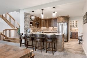 una cucina a pianta aperta con armadi in legno e sgabelli da bar di Dreamers Peak at Shanty Creek Resort a Bellaire