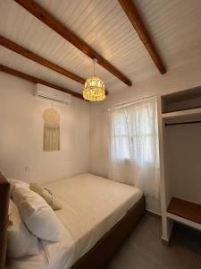 a bedroom with a bed and a chandelier at Kouri Escape in Kithnos