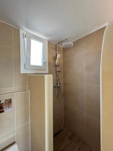 a small bathroom with a shower and a window at Kouri Escape in Kithnos +25 photos