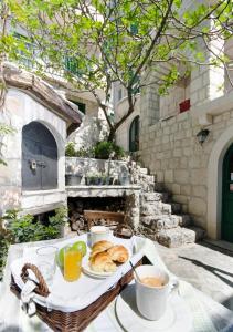 einen Tisch mit einem Tablett mit Speisen und Getränken darauf in der Unterkunft Stone cottage Lavandula in Baška Voda
