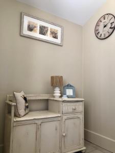 a room with a clock on the wall and a dresser at Le Cerisier Saint-Barbant in Saint-Barbant