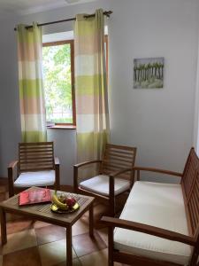 a living room with two chairs and a coffee table and a window at Villa am Schwarzen Meer in Eforie Nord