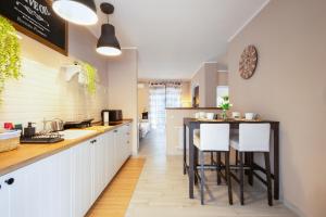 una cucina con un tavolo e alcuni mobili bianchi di Casa vacanze VesuviusView a Ercolano