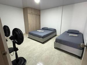 a bedroom with two beds and a fan at Almaré apartamento en Cartagena in Cartagena de Indias