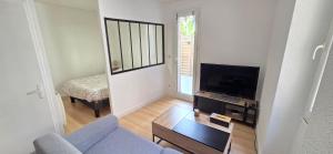 a living room with a couch and a television at T2 cœur de ville avec terrasse in Agen