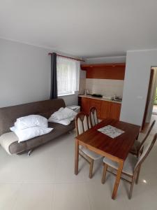 a living room with a couch and a table at Domimat-Lila in Dębki