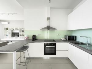 een keuken met witte kasten en een aanrechtblad bij Mèla Twin Villa Green Coast in Himare