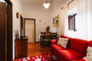ein Wohnzimmer mit einem roten Sofa und einem Tisch in der Unterkunft Apartamento 1 - Fundação de Veiros in Veiros