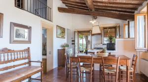 Una cocina y un comedor con mesa y sillas de madera. en Tenuta Bonelli, en Castelnuovo Berardenga
