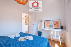 a bedroom with a blue bed and a desk at El Refugi de Mar in Palamós