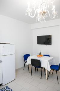 a dining room with a table with chairs and a chandelier at Appartamento Centrale Scalea in Scalea