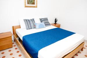 a bedroom with a large bed with a blue blanket at Appartamento Centrale Scalea in Scalea