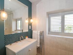 a bathroom with a sink and a mirror at The Annexe, Cleveley Mill in Chipping Norton