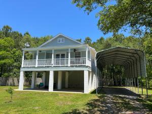 a large white house with a porch and an archway at Coastal Charm in Bay Saint Louis