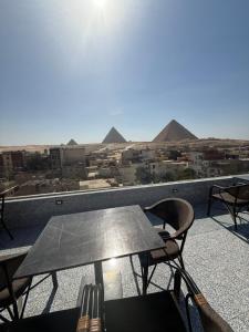 un tavolo e sedie su un balcone con piramidi di Middle East pyramid view a Il Cairo