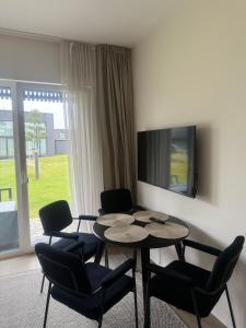 a living room with a table and chairs and a tv at Mano Jūra - apartamentų nuoma Mano Jūra 3 kvartale in Palanga