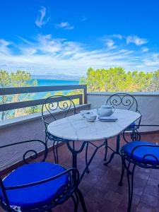 a table and chairs on a balcony with a view of the ocean at Terrazza sul mare in Porto Santo Stefano