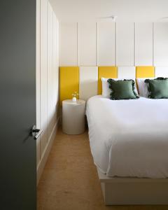 1 dormitorio con 2 camas y pared amarilla y blanca en South Beach Boutique Motel, en Southampton