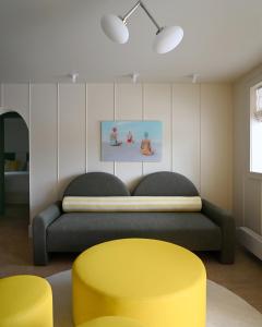 1 dormitorio con cama y taburete amarillo en South Beach Boutique Motel, en Southampton 1 foto más