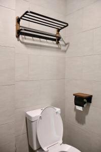a bathroom with a toilet and a toilet paper dispenser at Amber Haus - deLofts Emporium - 4pax VH 13 in Kuching +34 photos