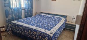 a bedroom with a bed with a blue and white comforter at Attico Alvorada in Porto Santa Margherita di Caorle +20 photos