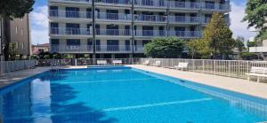 a large swimming pool in front of a building at Attico Alvorada in Porto Santa Margherita di Caorle
