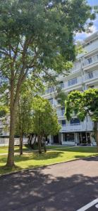 a large white building with trees in front of it at Attico Alvorada in Porto Santa Margherita di Caorle