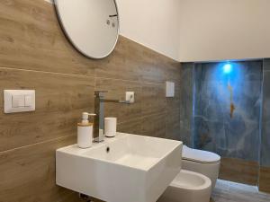 a bathroom with a sink and a mirror and a toilet at Isid'Oro Rooms - 50m dal mare in Sant'Isidoro +49 photos