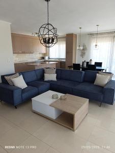 a living room with a blue couch and a table at Pearl Apartments in Ofrínion +6 photos