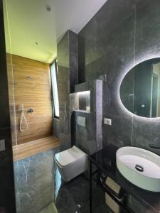 a bathroom with a sink and a toilet and a mirror at Sueño Luxury Villa in Durrës