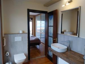 a bathroom with a sink and a toilet and a mirror at Villa Angela in San Benedetto del Tronto
