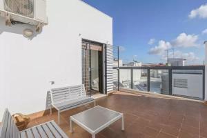 a balcony with a bench and a view of the city at Centro a todo confort, Atico 2 dormitorios con terraza in Dos Hermanas