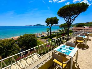 a balcony with a table and chairs and the ocean at Villa Magnolia in Formia