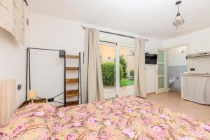 オルビアにあるSplendido Monolocale con Giardino Olbiaのベッドと大きな窓のある寝室